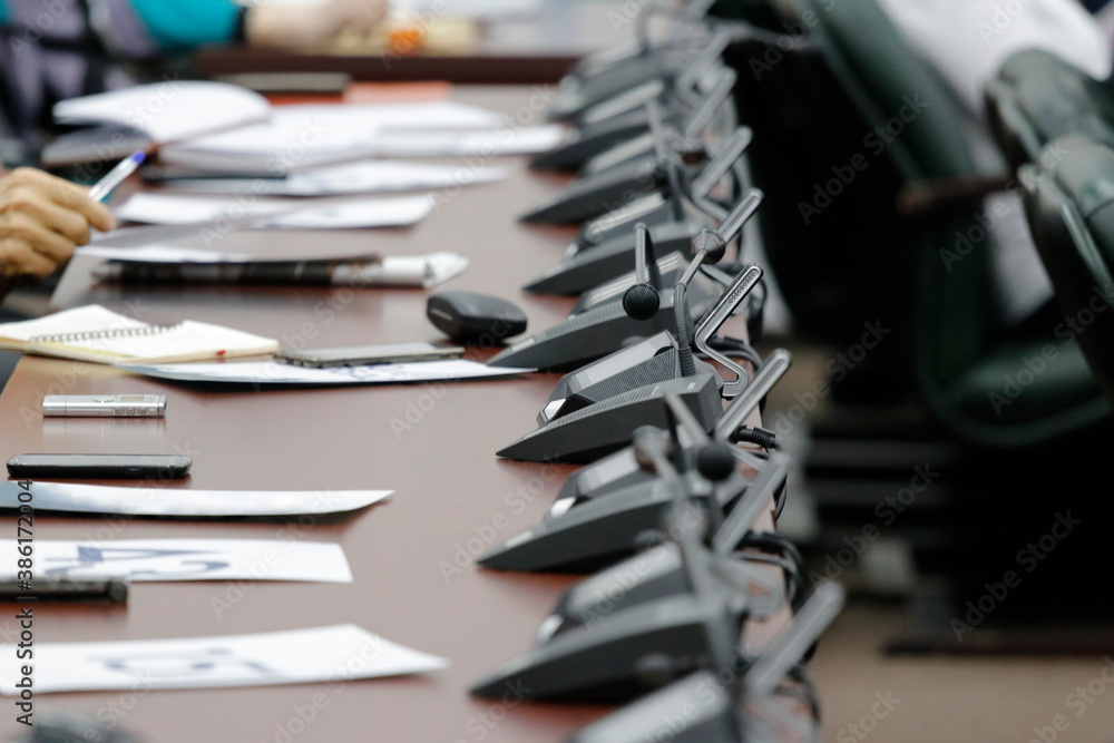 As part of the electronic voting and conference call system. On the table are business papers, pens, laptops, smartphones As part of the electronic voting and conference call system. On the table are business papers, pens, laptops, smartphones