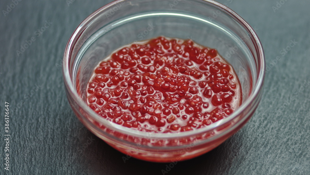 Appetizing background of red caviar. Salmon or trout caviar is laid out in a plate and rotates Appetizing background of red caviar. Salmon or trout caviar is laid out in a plate and rotates