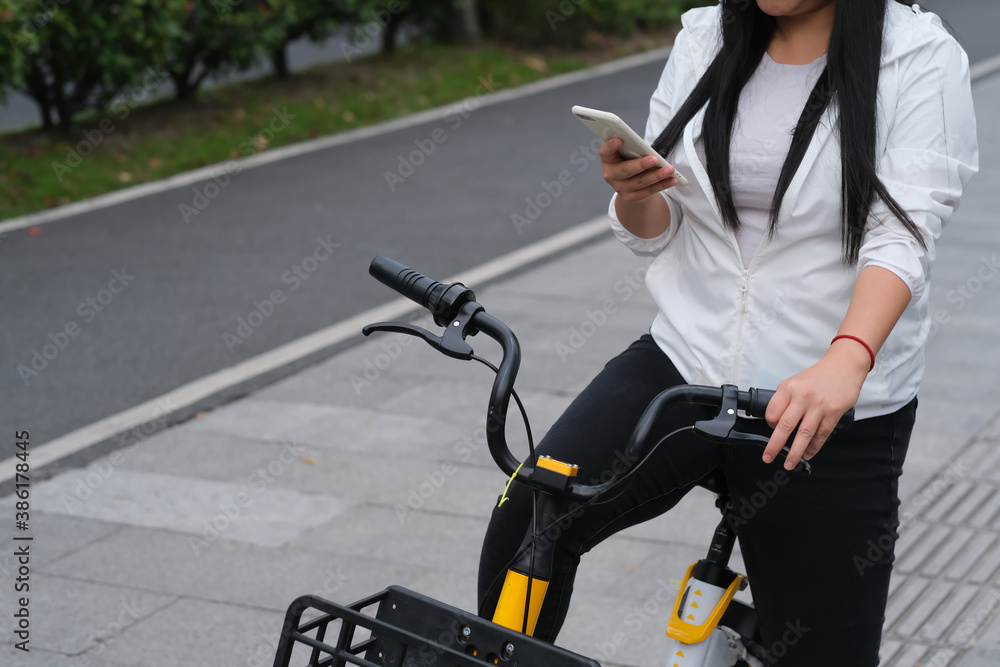 Obraz premium woman using phone checking route while sitting on bike