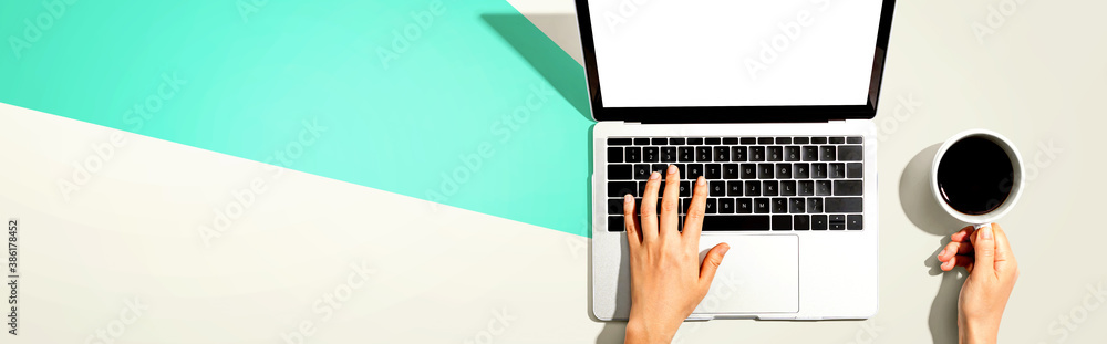 Person using a laptop computer from above Person using a laptop computer from above