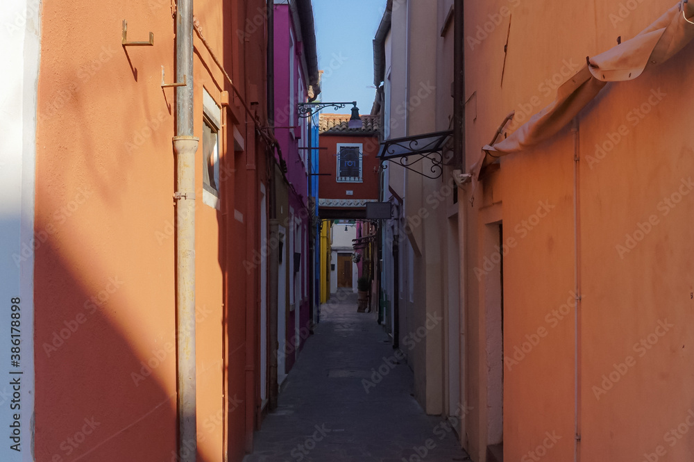 Fototapeta premium Venice, Italy - 23/01/18 A quiet alley with orange walls. A dark but cozy atmospheric street in venice. 