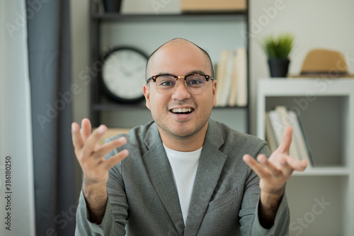 Wallpaper Mural A man around the age of 35. Working at home by meeting video conference looking at camera. He was wearing a grey suit and glasses. Asian businessman work from home talking on screen. Torontodigital.ca