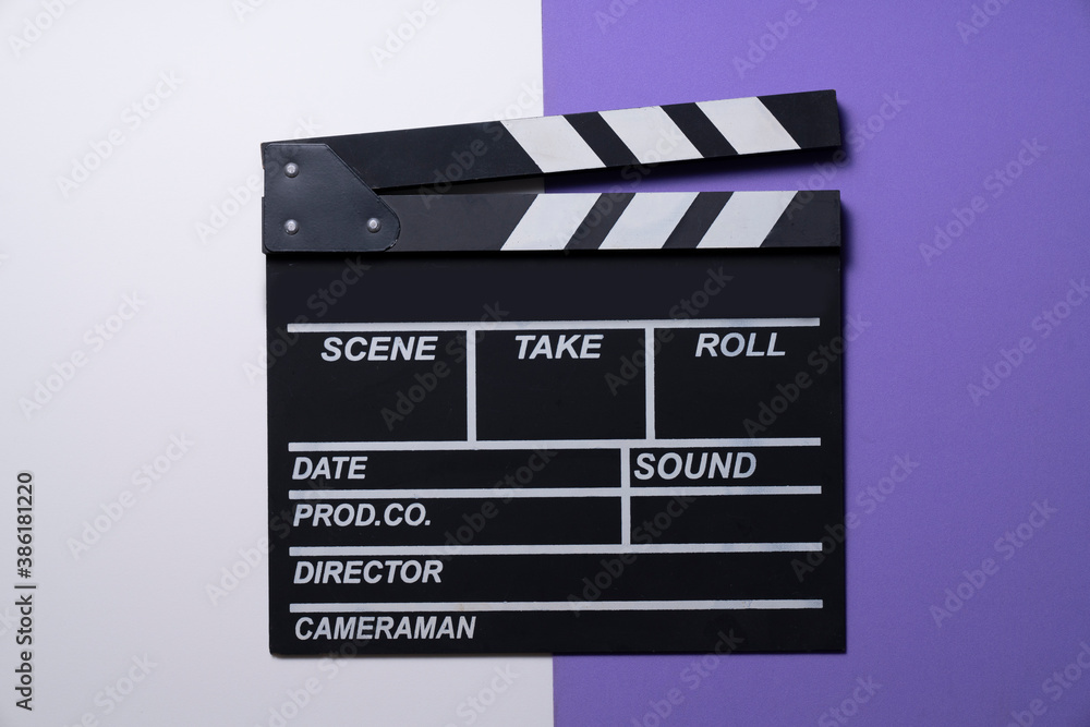 movie clapper on white and purple table background ; film, cinema and video photography concept
