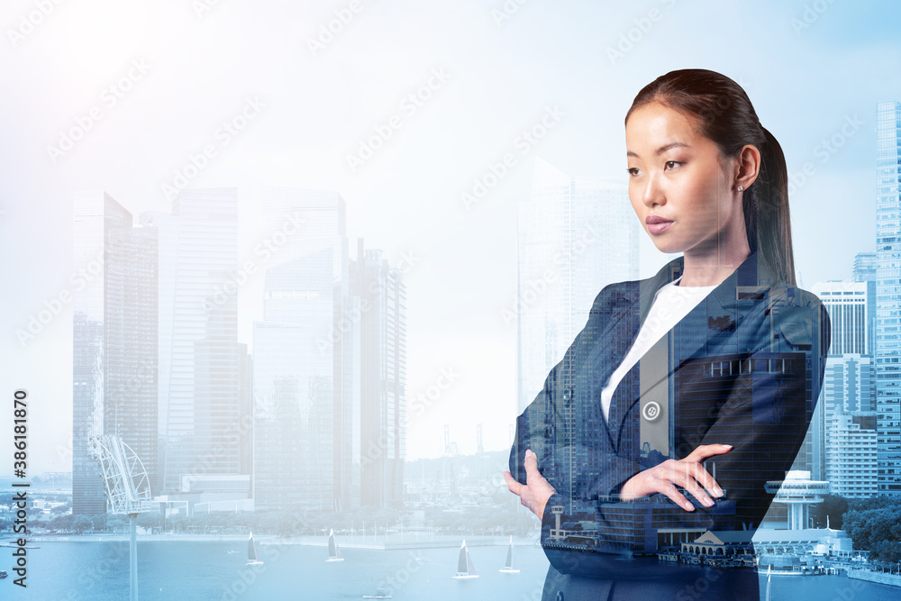 Prosperous Asian businesswoman in suit in crossed arms pose. Singapore cityscape. The concept of woman in business. Financial downtown. Double exposure. Prosperous Asian businesswoman in suit in crossed arms pose. Singapore cityscape. The concept of woman in business. Financial downtown. Double exposure.