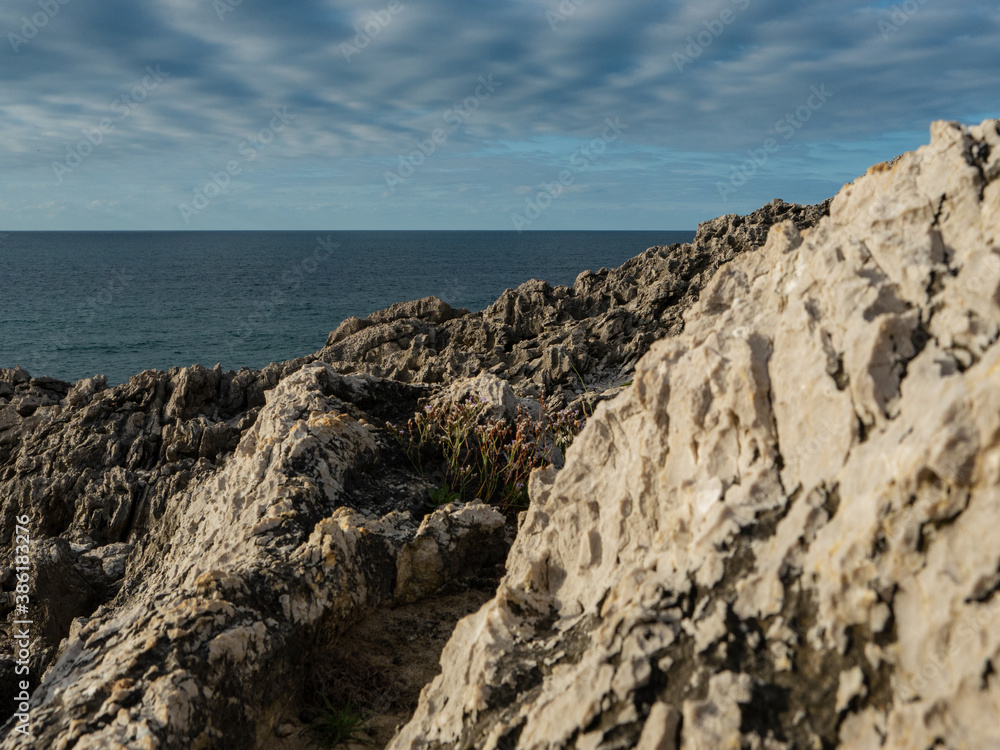 Cliffs by the sea under a blue cloudy sky Cliffs by the sea under a blue cloudy sky