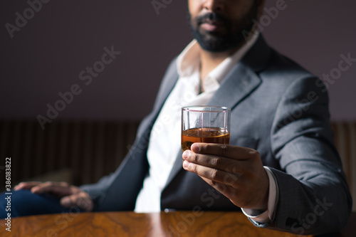 wine glass in hand businessman wearing white shirt grey suit dark and moody environment