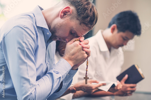 Christians and Bible study concept. Group of discipleship Studying the Word Of God in church and Christians holding each others hand praying together photo