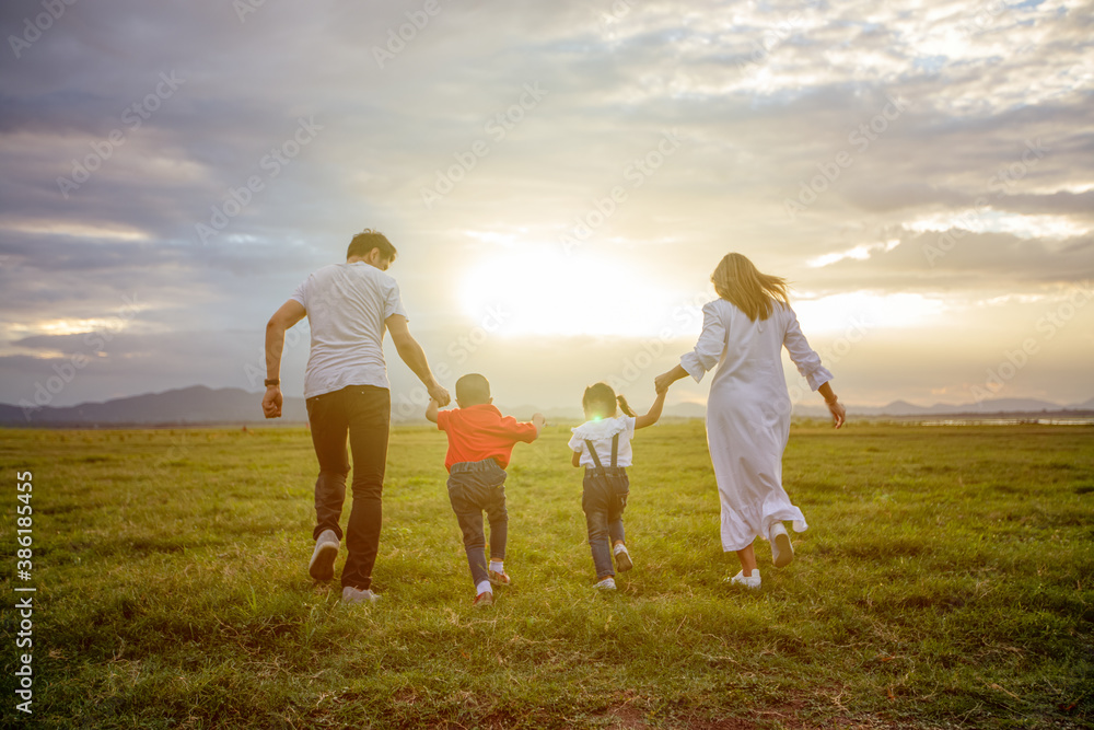 Asian family walking and running on the Meadow at sunset with happy emotion. Family, Holiday and Travel concept. Asian family walking and running on the Meadow at sunset with happy emotion. Family, Holiday and Travel concept.