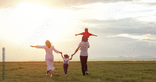 Asian family walking and running on the Meadow at sunset with happy emotion. Family  Holiday and Travel concept.