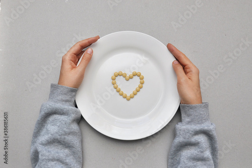 Heart sign from pills on a white plate. Treatment of heart diseases