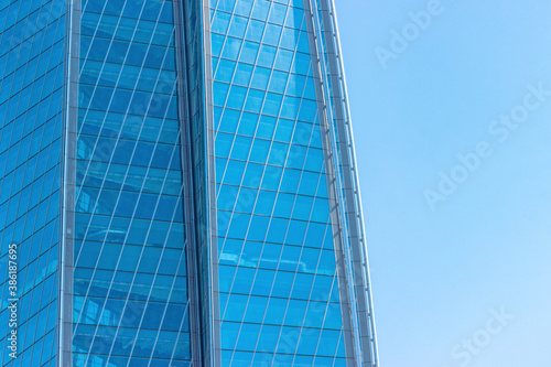 sky and exterior glass walls of a modern Corporate building. Business offices of skyscraper on blue sky background.