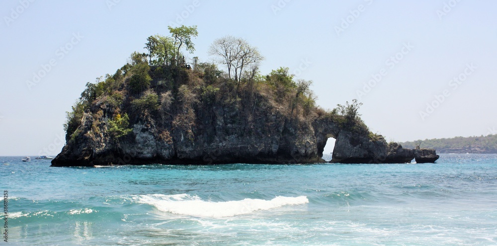 Rocky island with natural arch at Crystal Bay, Nusa Penida, Indonesia