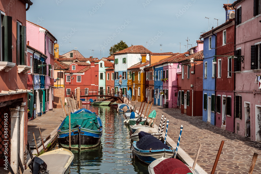 Burano canal with boats lined with colored houses