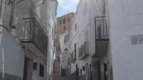 Typical andalusian street with church tower with bell