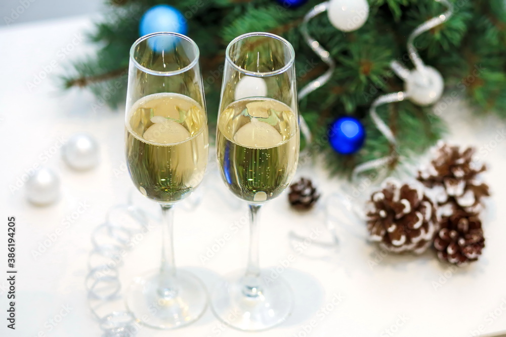 Two glasses of champagne composition with Christmas and new year decorations on a blurry background top view Two glasses of champagne composition with Christmas and new year decorations on a blurry background top view