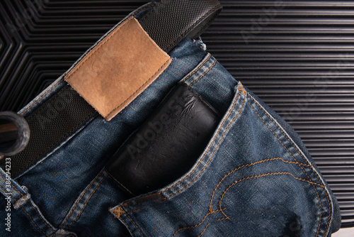 black wallet in the back of blue Jean pocket