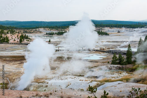 Panoramic view over Norris Geyser Basin and its geothermal features such as fumaroles, hot pools and geysers. A boardwalk crosses the delicate and hot land. Taken from Porcelain Terrace overlook
