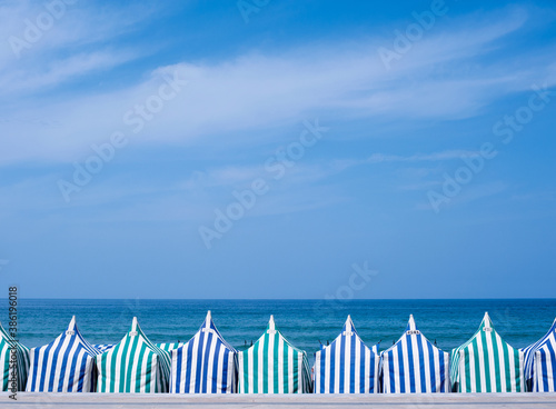 Casetas de playa de rayas en Zarautz (Gipuzkoa) en un día soleado de verano con el mar al fondo photo