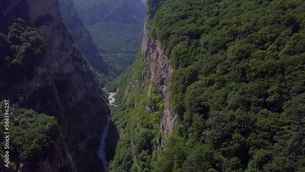 Deep gorge in the middle of the mountains. A stormy river flows at the bottom of the gorge. Drone shot Deep gorge in the middle of the mountains. A stormy river flows at the bottom of the gorge. Drone shot