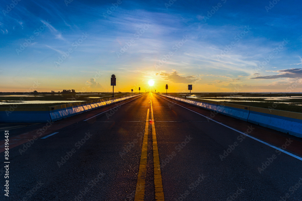 Fototapeta premium Beautiful sun rising sky with asphalt highways road in rural scene