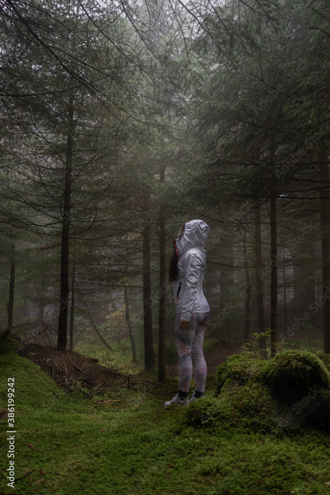 Fototapeta premium woman in the middle of the dark forest