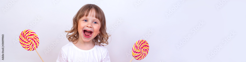 Narrow photo of a funny little girl with big lollipops. Narrow photo of a funny little girl with big lollipops.