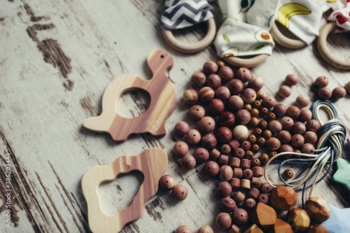 Wooden organic baby teether toy details. Flat lay set for making children's wooden toys, food grade silicone, juniper tree, beech, teethers and rattles for newborns © Erika Parfenova