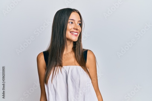 Young hispanic woman wearing casual clothes looking away to side with smile on face, natural expression. laughing confident. © Krakenimages.com