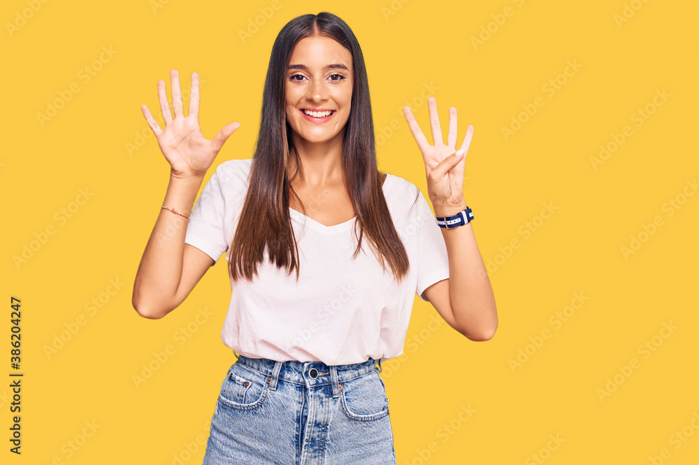 Young hispanic woman wearing casual white tshirt showing and pointing up with fingers number nine while smiling confident and happy. Young hispanic woman wearing casual white tshirt showing and pointing up with fingers number nine while smiling confident and happy.