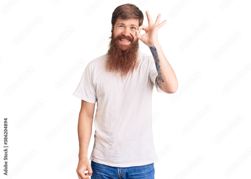 Handsome young red head man with long beard wearing casual white tshirt smiling positive doing ok sign with hand and fingers. successful expression. Handsome young red head man with long beard wearing casual white tshirt smiling positive doing ok sign with hand and fingers. successful expression.
