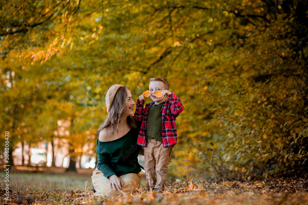 Happy young mother playing and having fun with her little baby son on sunshine warm autumn day in the park. Happy family concept Happy young mother playing and having fun with her little baby son on sunshine warm autumn day in the park. Happy family concept