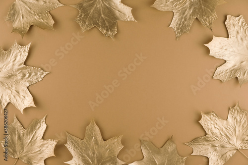 Autumn composition. Frame made of autumn golden maple leaves on nude background. Flat lay  top view  copy space