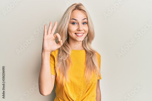 Wallpaper Mural Beautiful caucasian blonde girl wearing casual tshirt smiling positive doing ok sign with hand and fingers. successful expression. Torontodigital.ca