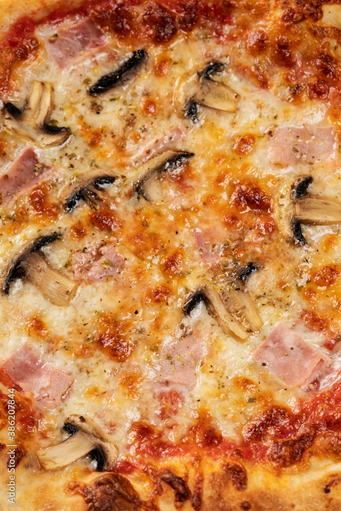Homemade pizza with champignon mushrooms and ham