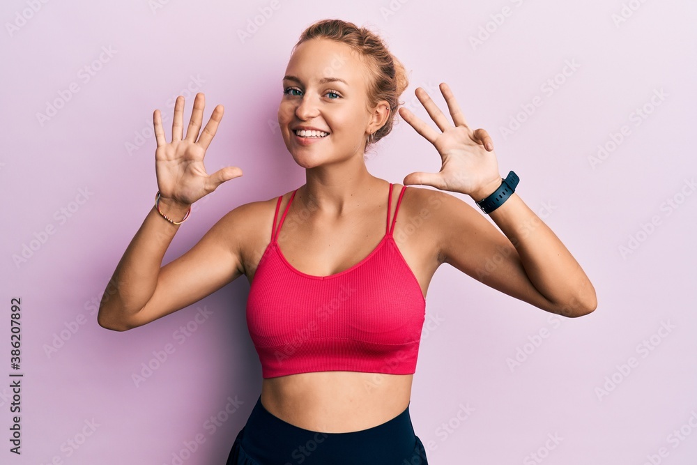 Beautiful caucasian woman wearing sportswear showing and pointing up with fingers number nine while smiling confident and happy.