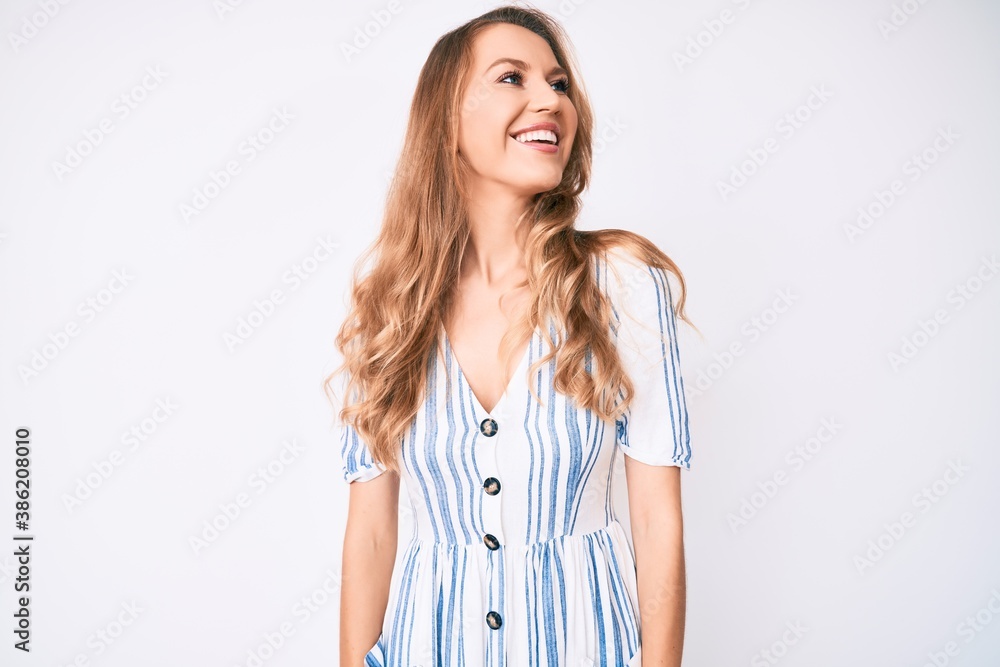 Young caucasian woman with blond hair wearing summer dress looking to side, relax profile pose with natural face and confident smile. Young caucasian woman with blond hair wearing summer dress looking to side, relax profile pose with natural face and confident smile.