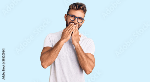Schilderij op canvas Young hispanic man wearing casual clothes and glasses laughing and embarrassed g