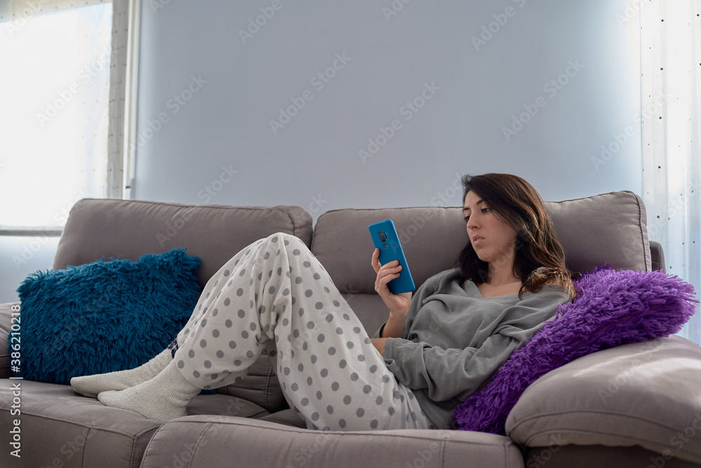 Obraz premium Woman at home with a smartphone
