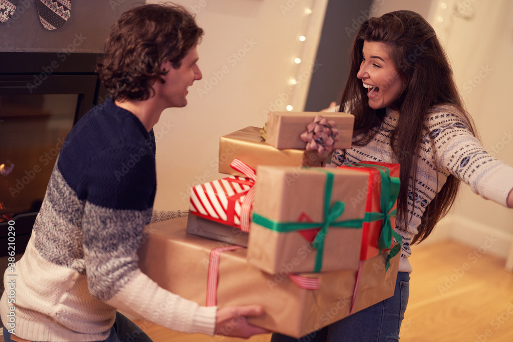 Adult couple with present over fireplace Adult couple with present over fireplace