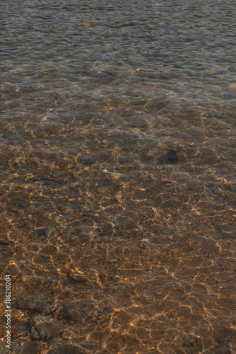 Mediterranean sea detail with clear water, wave reflections, and ripples vertical