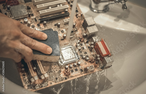 Washing the motherboard from the computer in the sink