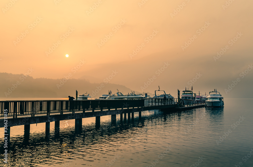 Fototapeta premium Beautiful sun rise scene of boats at pier at Sun Moon Lake, Taiwan.
