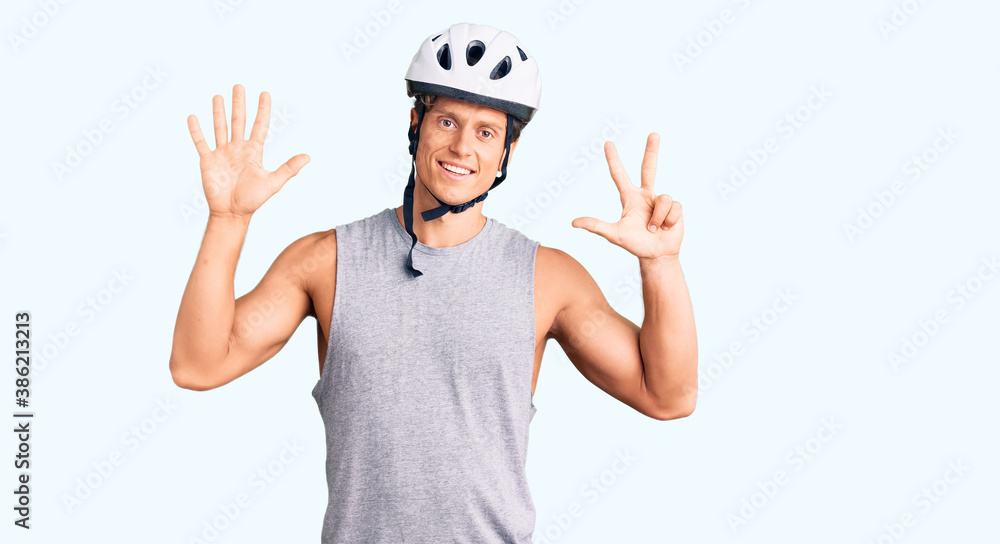 Naklejka premium Young handsome man wearing bike helmet showing and pointing up with fingers number eight while smiling confident and happy.