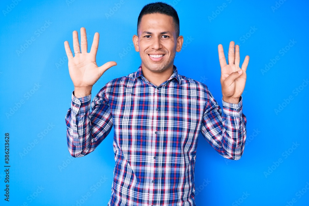 Naklejka premium Young handsome latin man wearing casual clothes showing and pointing up with fingers number nine while smiling confident and happy.