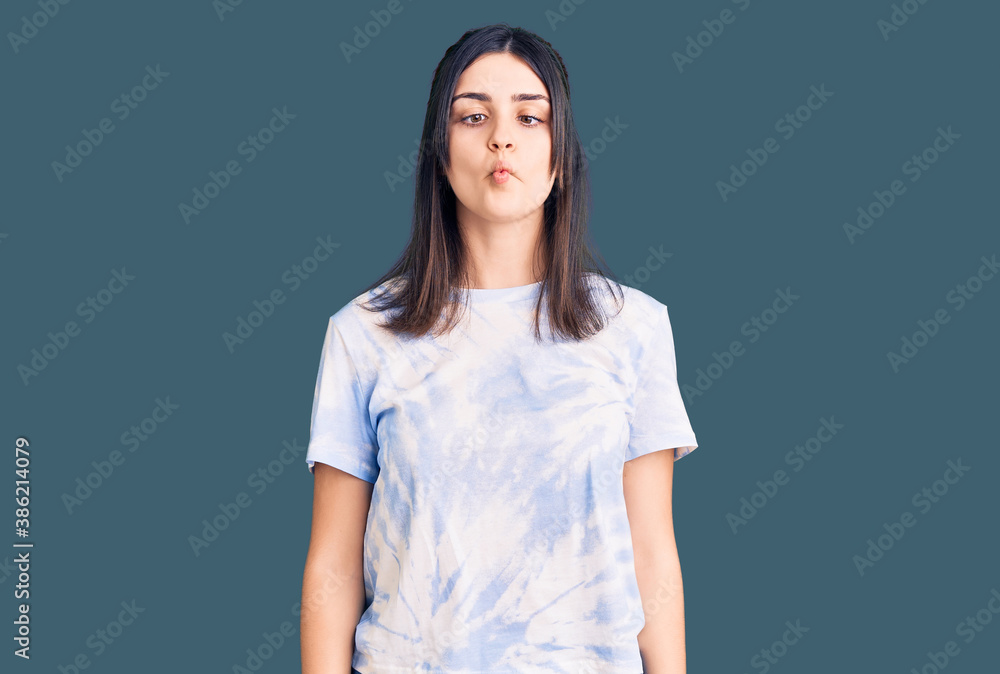 Young beautiful girl wearing casual t shirt making fish face with lips, crazy and comical gesture. funny expression. Young beautiful girl wearing casual t shirt making fish face with lips, crazy and comical gesture. funny expression.