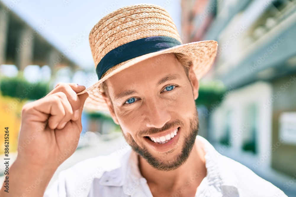 Handsome caucasian man wearing summer hat and flowers shirt smiling happy outdoors Handsome caucasian man wearing summer hat and flowers shirt smiling happy outdoors