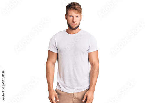 Young caucasian man wearing casual white tshirt skeptic and nervous, frowning upset because of problem. negative person.