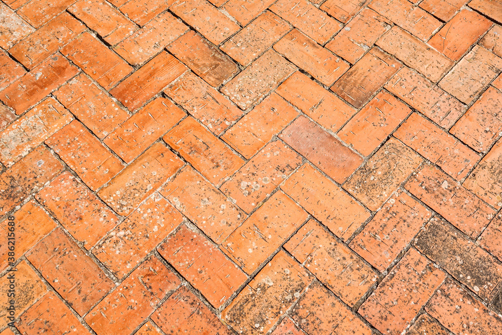 Brick pavement placed in spike, urban background and texture of a spanish courtyard Brick pavement placed in spike, urban background and texture of a spanish courtyard