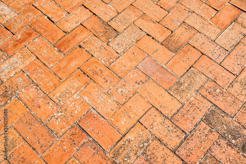Brick pavement placed in spike, urban background and texture of a spanish courtyard