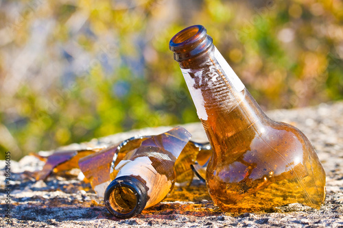 Photography Shattered beer bottle resting on the ground: alcoholism concept - toned image